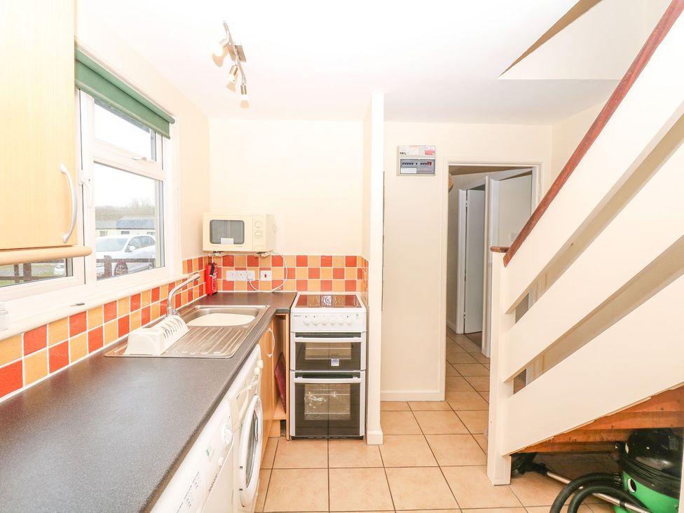 A kitchen with appliances and counters at Court House Farmhouse in Charmouth