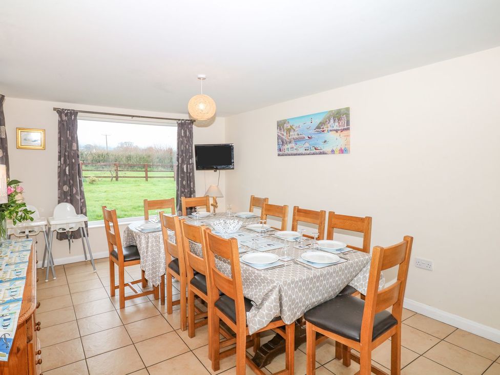 A dining room with a large table and chairs at Court House Farmhouse in Charmouth