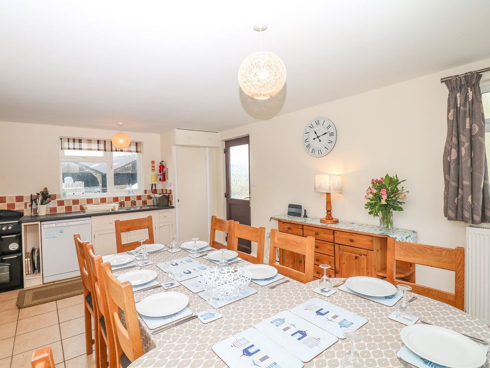 A kitchen with dining table and chairs at Court House Farmhouse in Charmouth