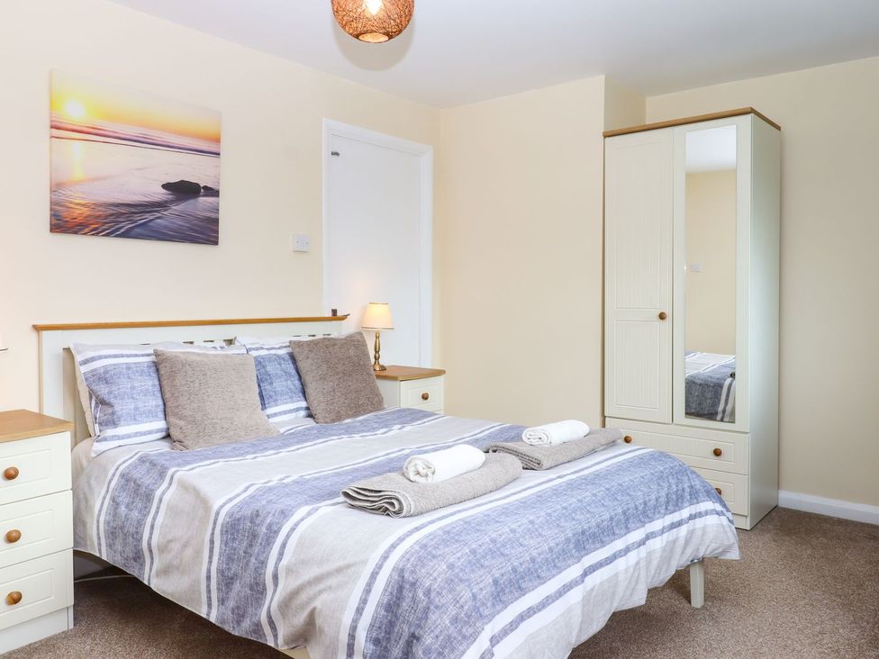 A bedroom with a bed and wardrobe at Court House Farmhouse in Charmouth