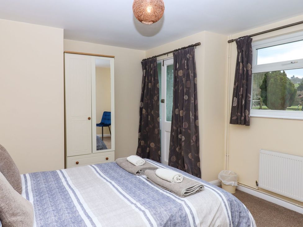 A bedroom with a bed and wardrobe at Court House Farmhouse, Charmouth