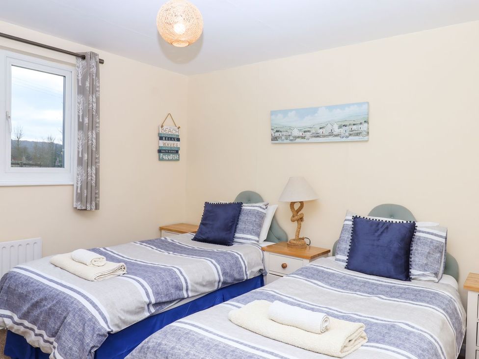 A bedroom with two beds and a window at Court House Farmhouse in Charmouth