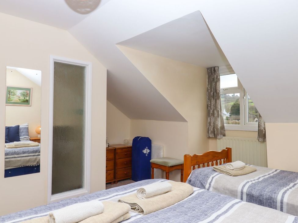 A bedroom with two beds and a dresser at Court House Farmhouse in Charmouth