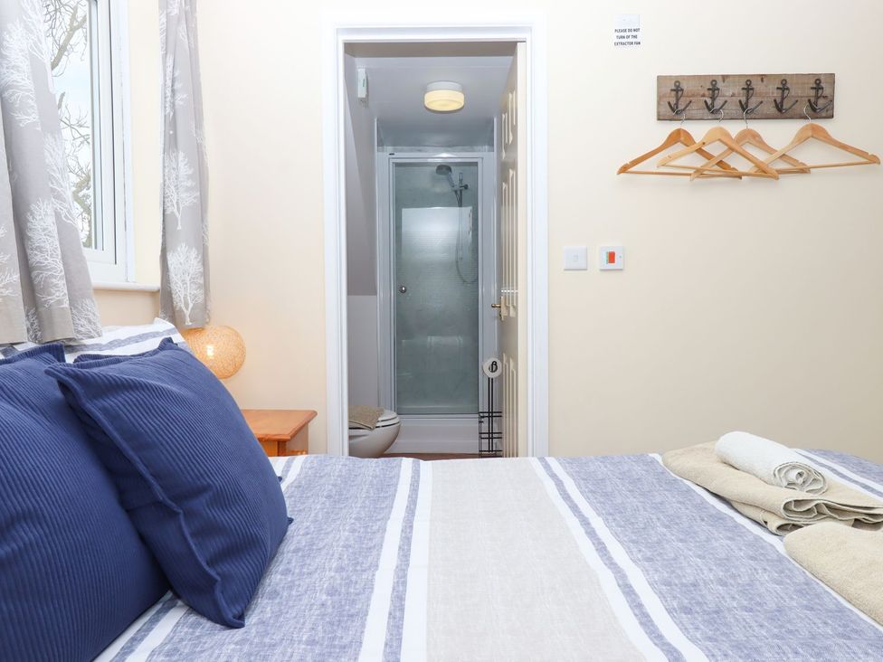 A bedroom with a bed and an adjoining bathroom at Court House Farmhouse in Charmouth