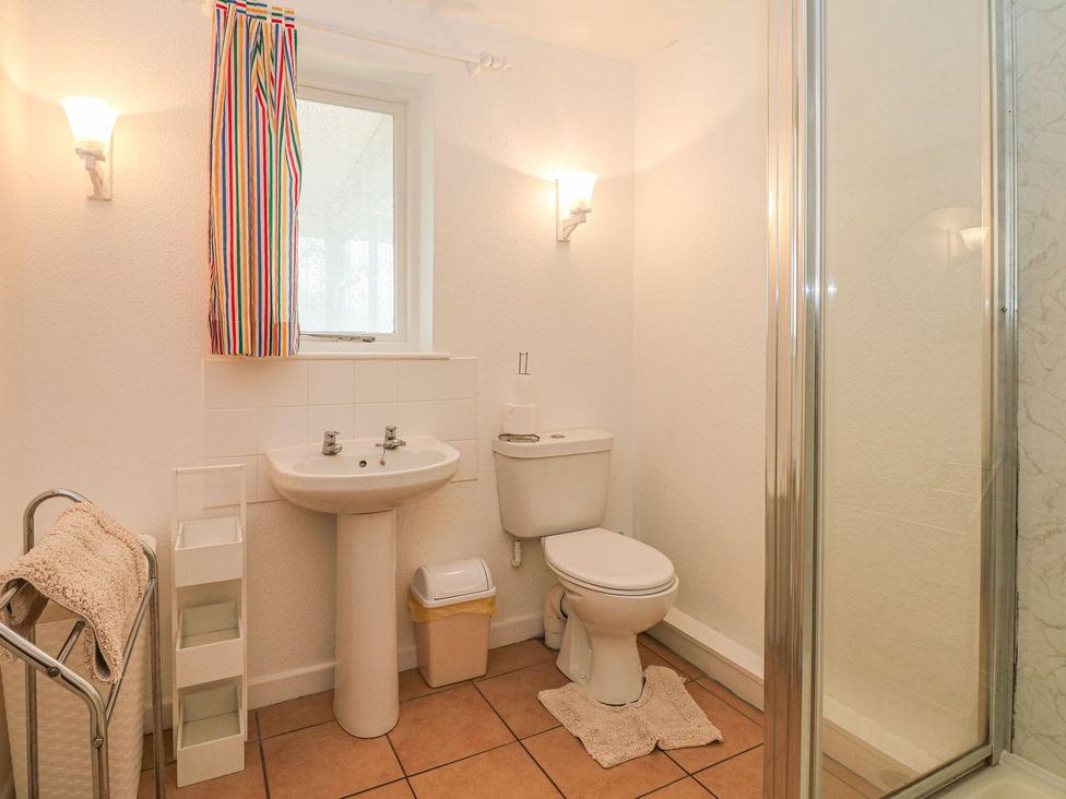 A bathroom with sink, toilet, shower and towel rack at Court House Farmhouse in Charmouth