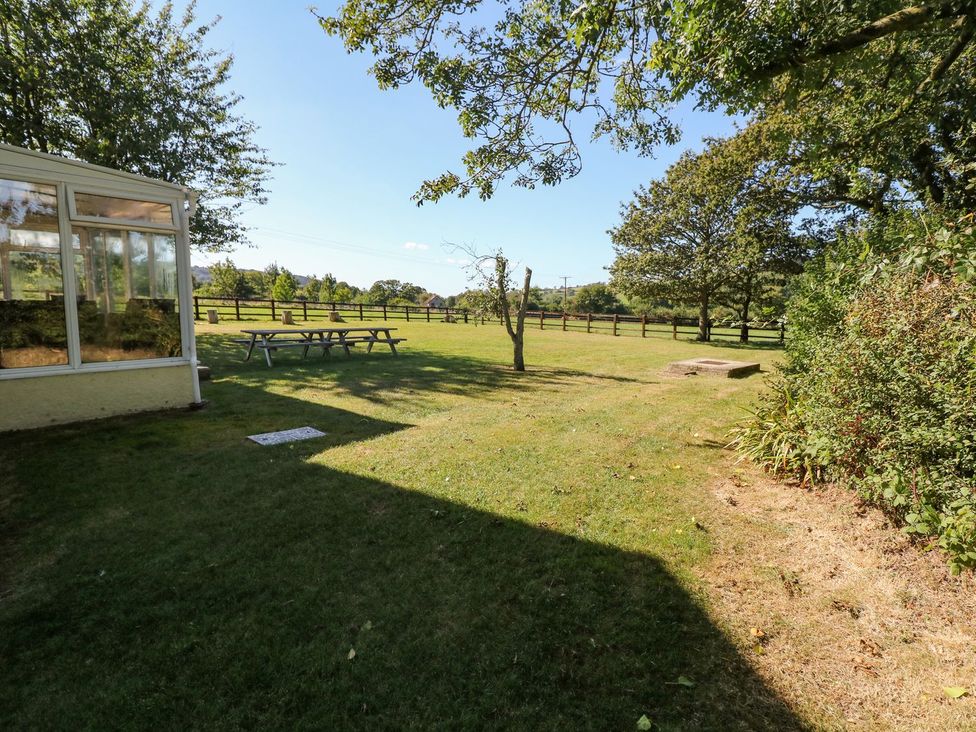 A garden with a table and trees at Court House Farmhouse in Charmouth