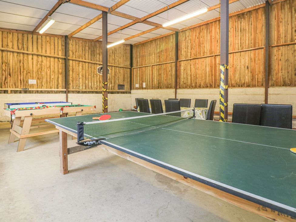 A game room with a table tennis table and chairs at Court House Farmhouse in Charmouth