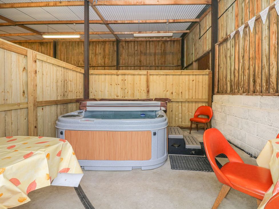 A hot tub with chairs and a table at Court House Farmhouse in Charmouth