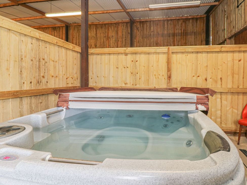A hot tub with wooden wall in Court House Farmhouse Charmouth