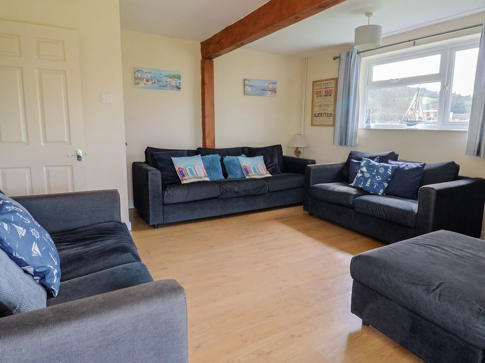 A living room with three sofas and a lamp at Court House Farmhouse in Charmouth