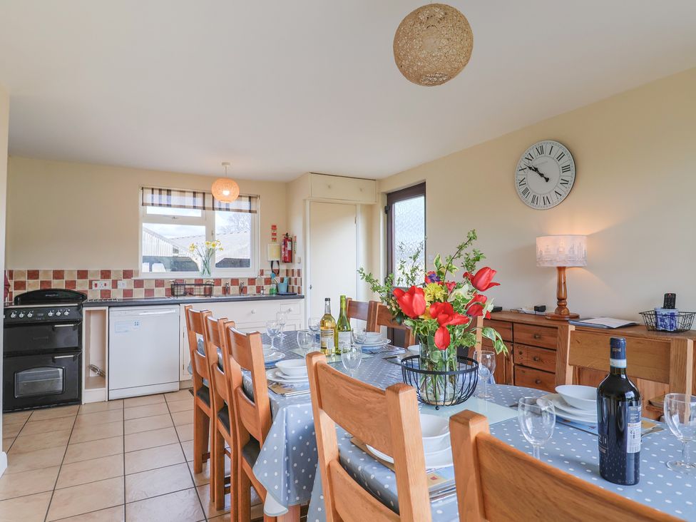 A kitchen with dining table and chairs at Court House Farmhouse in Charmouth