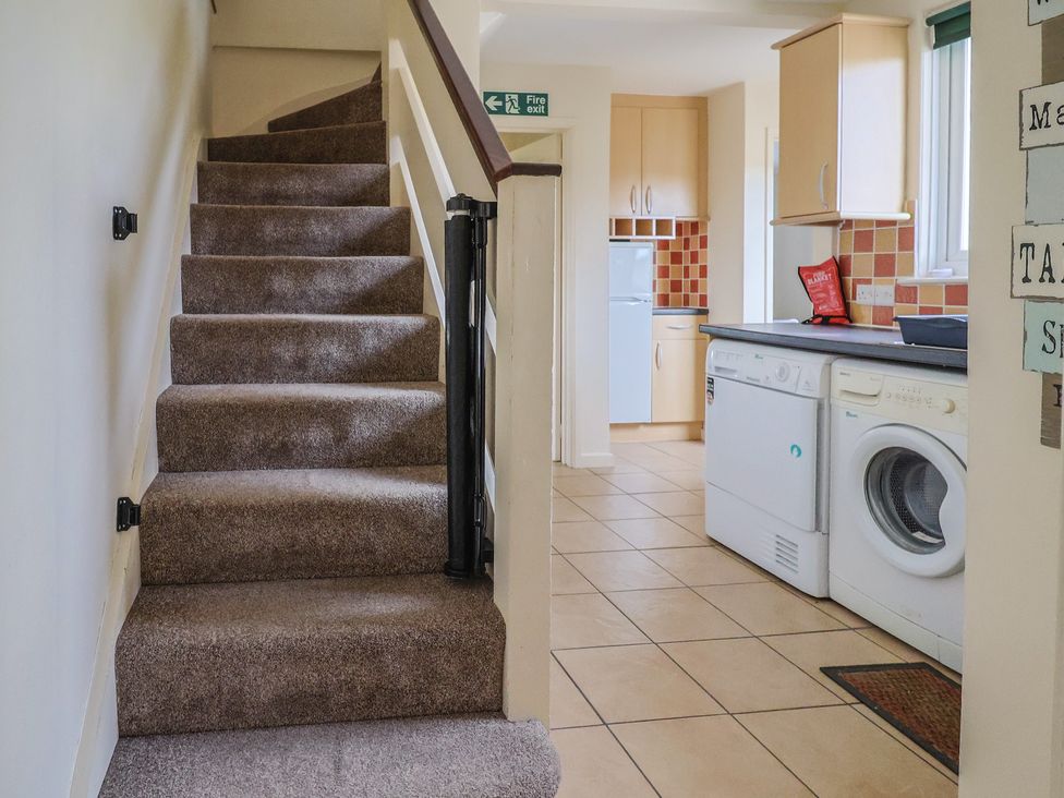 A kitchen with stairs leading to an upper floor at Court House Farmhouse in Charmouth