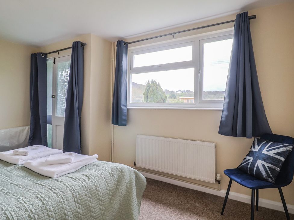A bedroom with a bed and towels at Court House Farmhouse in Charmouth