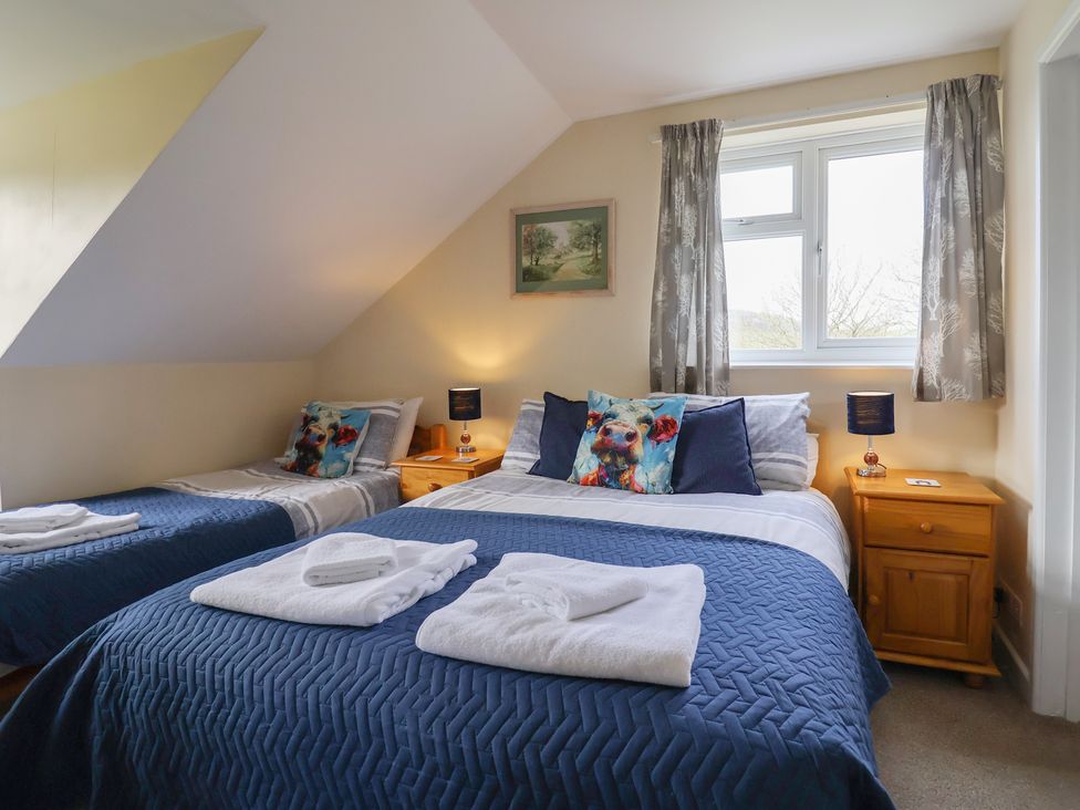 A bedroom with two beds and a nightstand at Court House Farmhouse in Charmouth