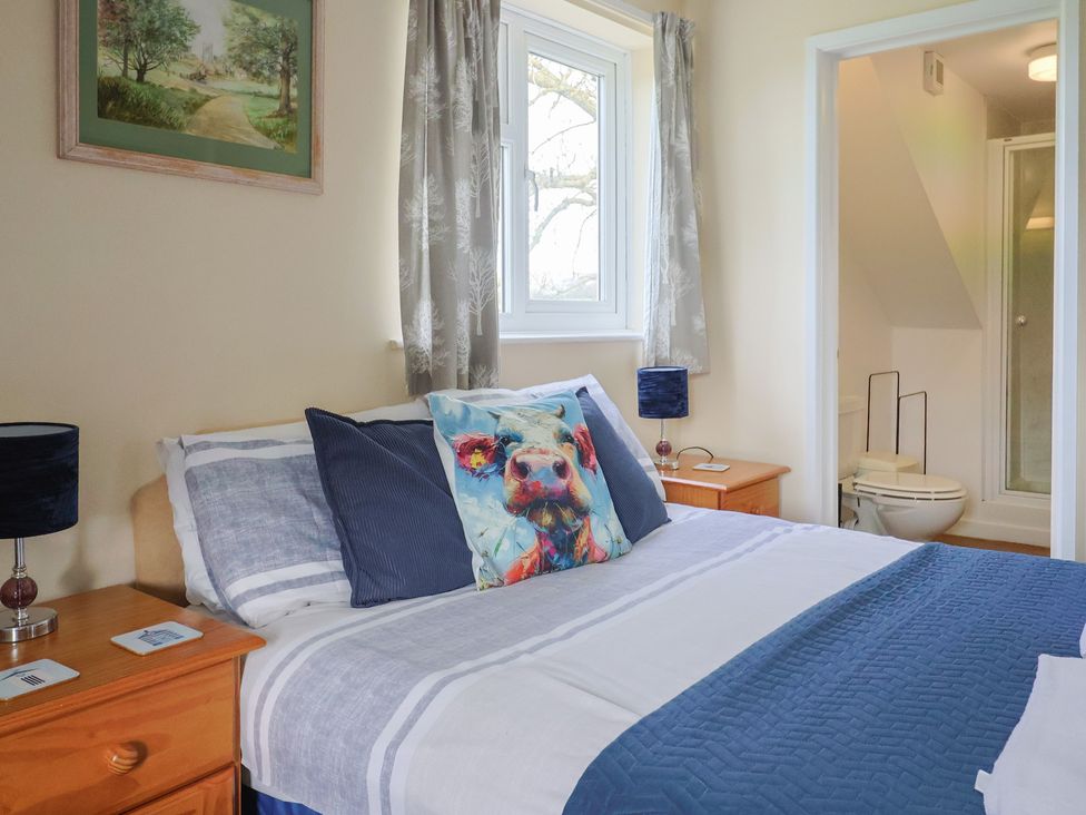 A bedroom with a bed and adjoining bathroom at Court House Farmhouse in Charmouth