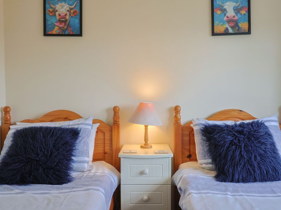 Two beds with pillows and a lamp in a bedroom at Court House Farmhouse in Charmouth