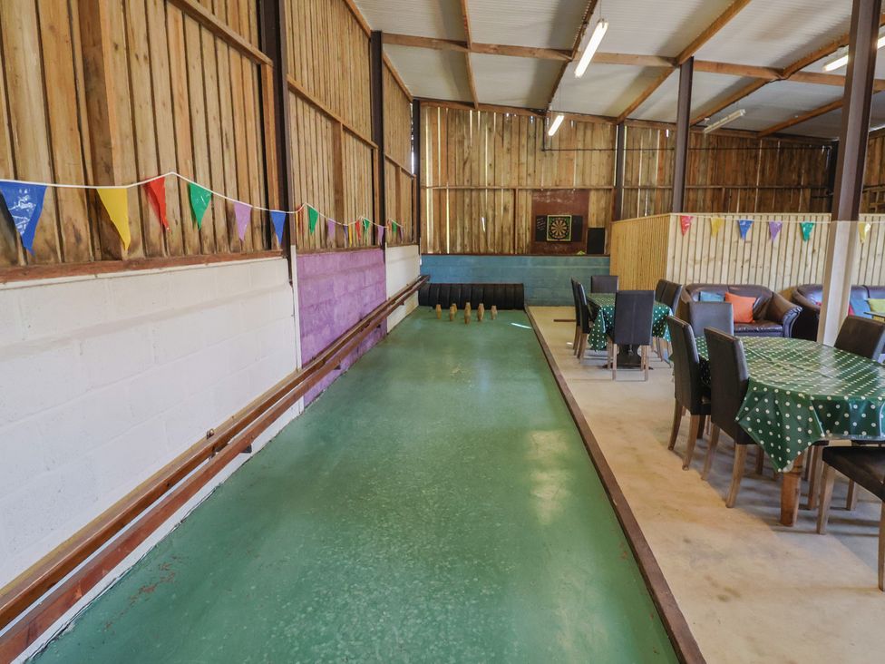 A games room with a bowling lane and seating at Court House Farmhouse in Charmouth