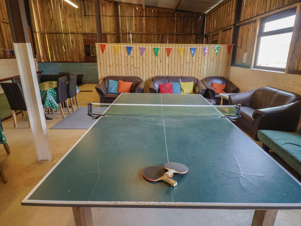 A game room with a ping pong table and couches at Court House Farmhouse in Charmouth