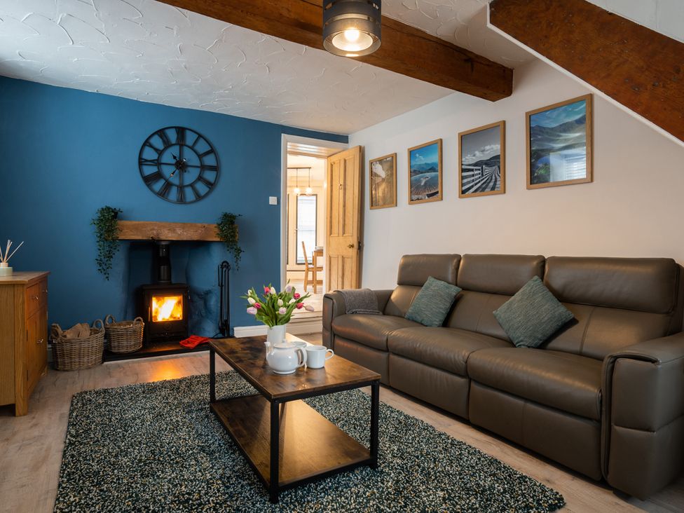 A living room with a sofa and fireplace at Garn View in Dolgellau