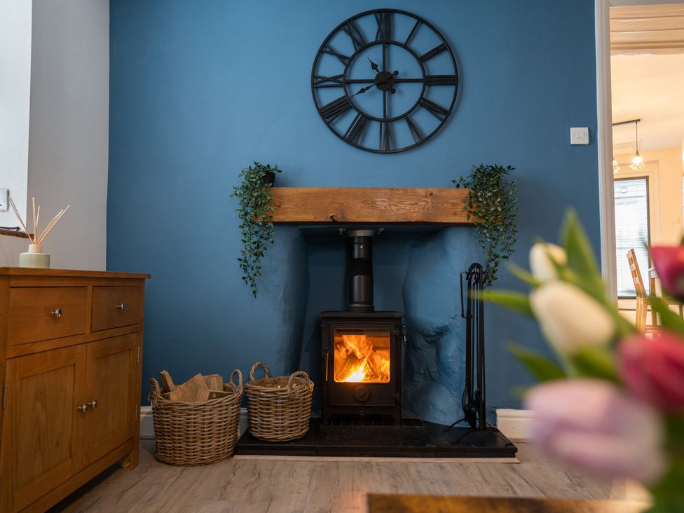 A living room with a fireplace and wooden mantel at Garn View in Dolgellau