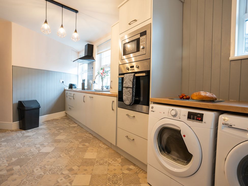 A kitchen with appliances and a washing machine at Garn View in Dolgellau