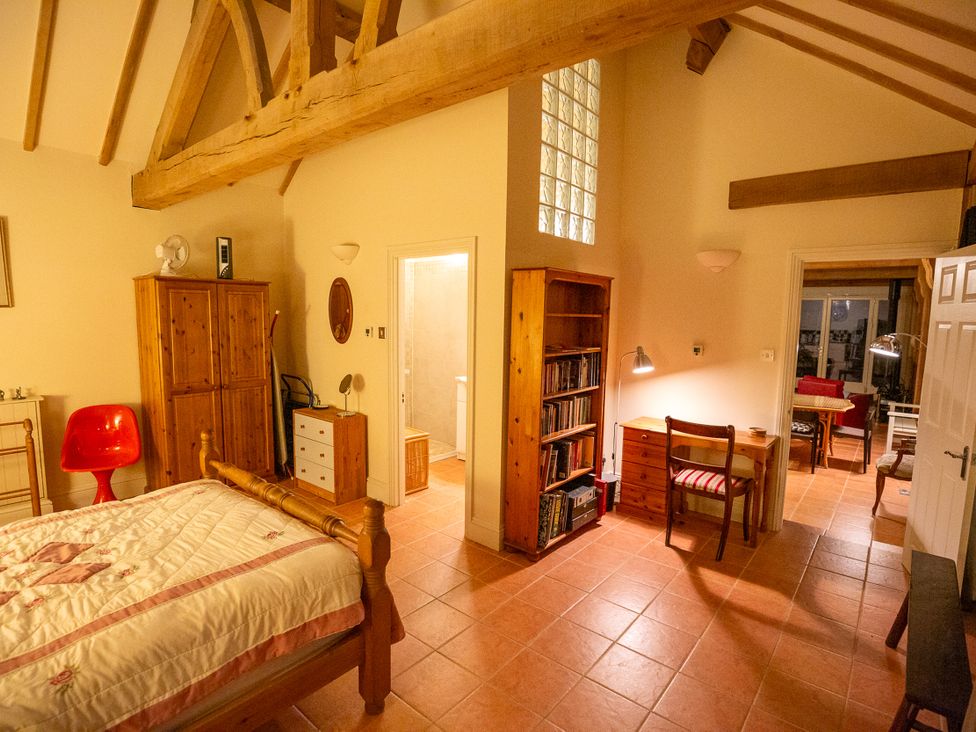 A bedroom with a bed, chair, and bookshelf at Nature's Lodge in Kidderminster