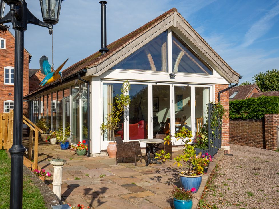 A conservatory with glass walls and plants outside at Nature's Lodge in Kidderminster