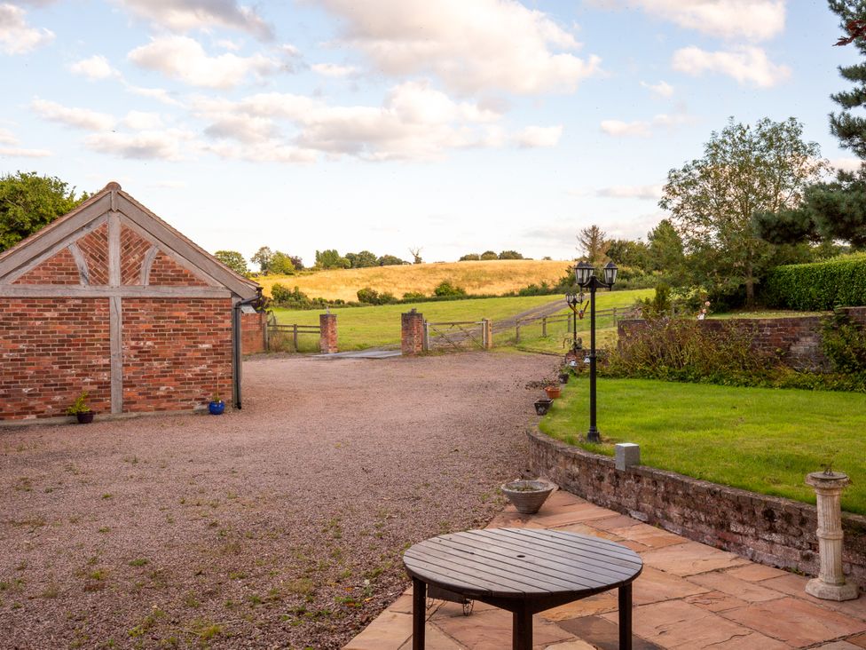 An outdoor area with a brick building and a gravel driveway at Nature's Lodge in Kidderminster