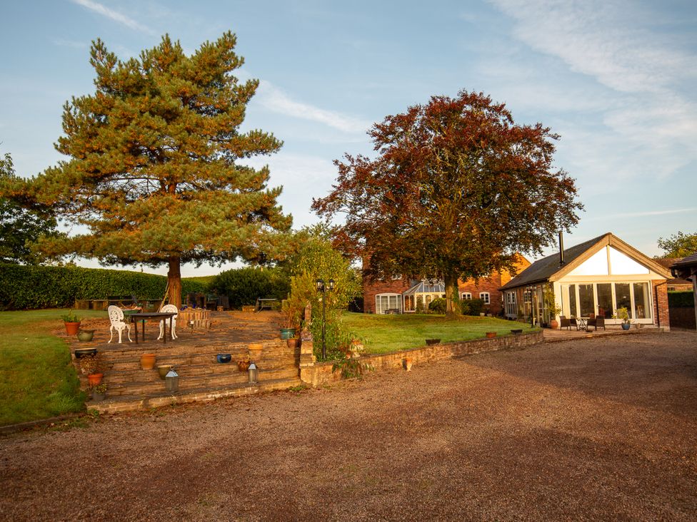 A garden with trees and patio furniture at Nature's Lodge in Kidderminster