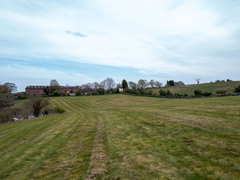 An outdoor view of a grassy field and buildings at Nature's Lodge in Kidderminster