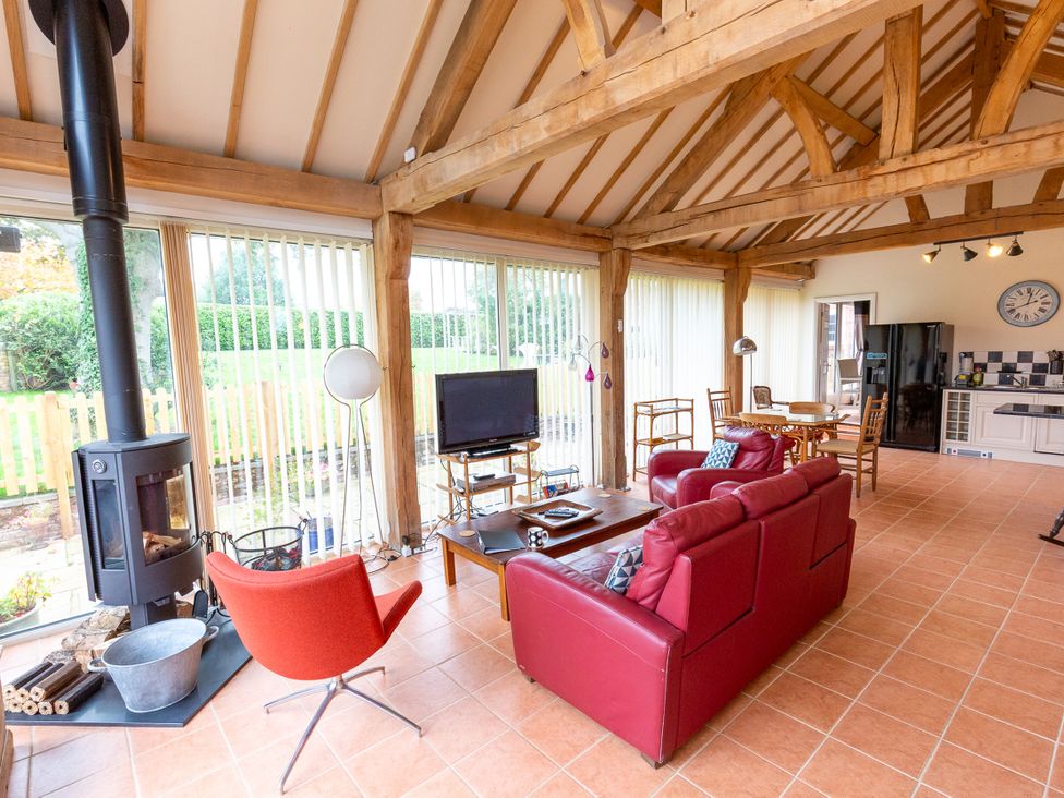 A living room with a fireplace and seating area at Nature's Lodge in Cookley