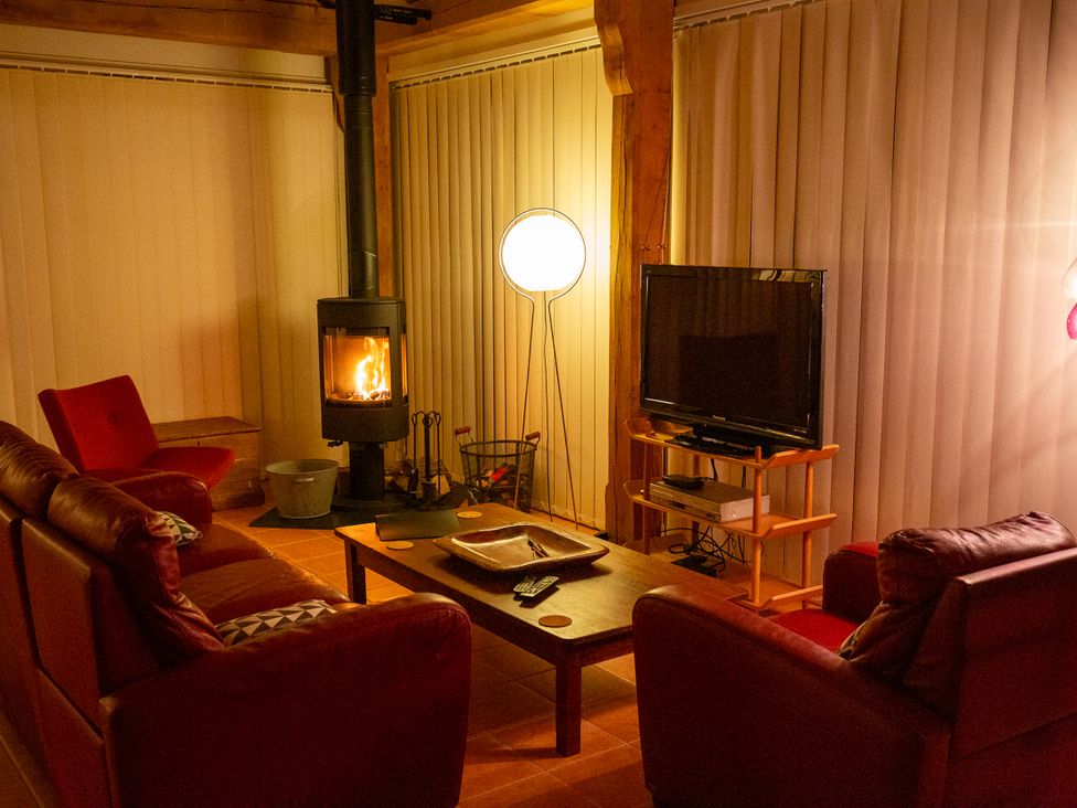 A living room with a fireplace and television at Nature's Lodge in Cookley