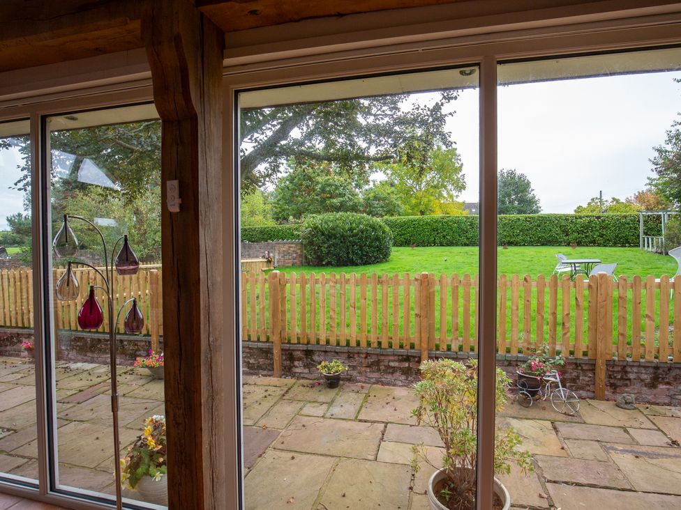 A garden view with a glass door and furniture at Nature's Lodge in Cookley