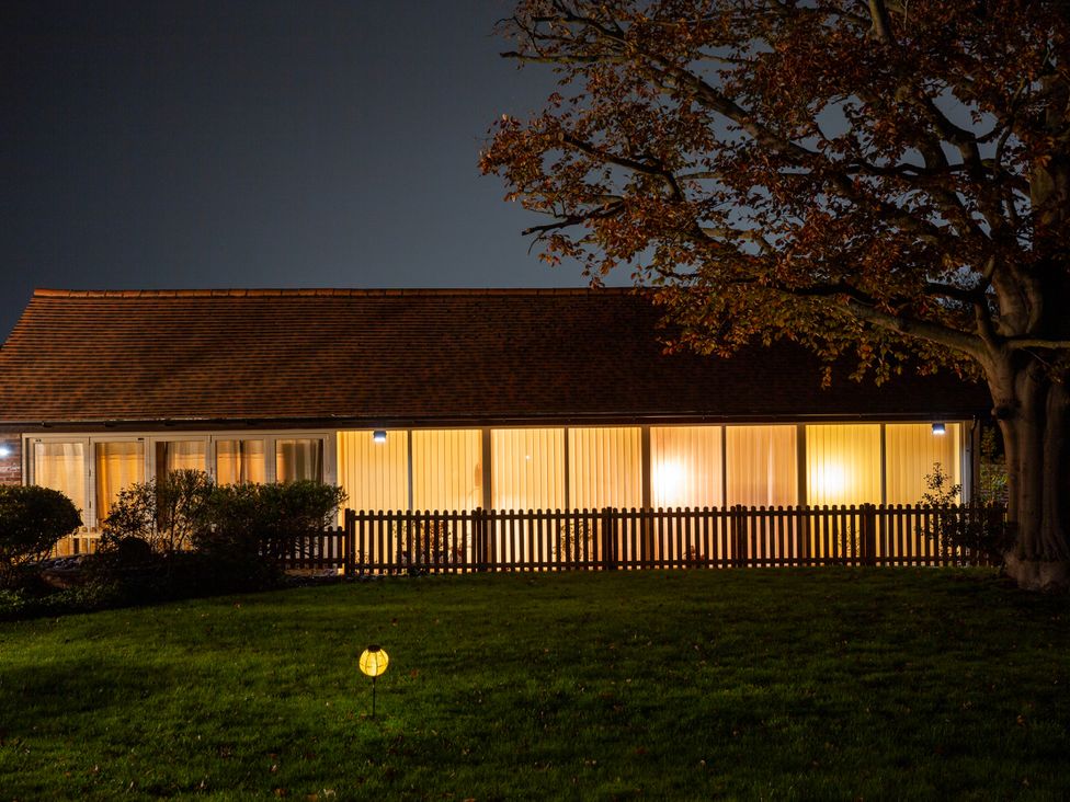 A house with lighting and a fence at Nature's Lodge in Cookley