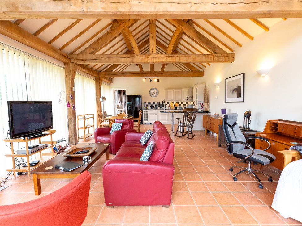 A living room with a television and sofa at Nature's Lodge in Cookley