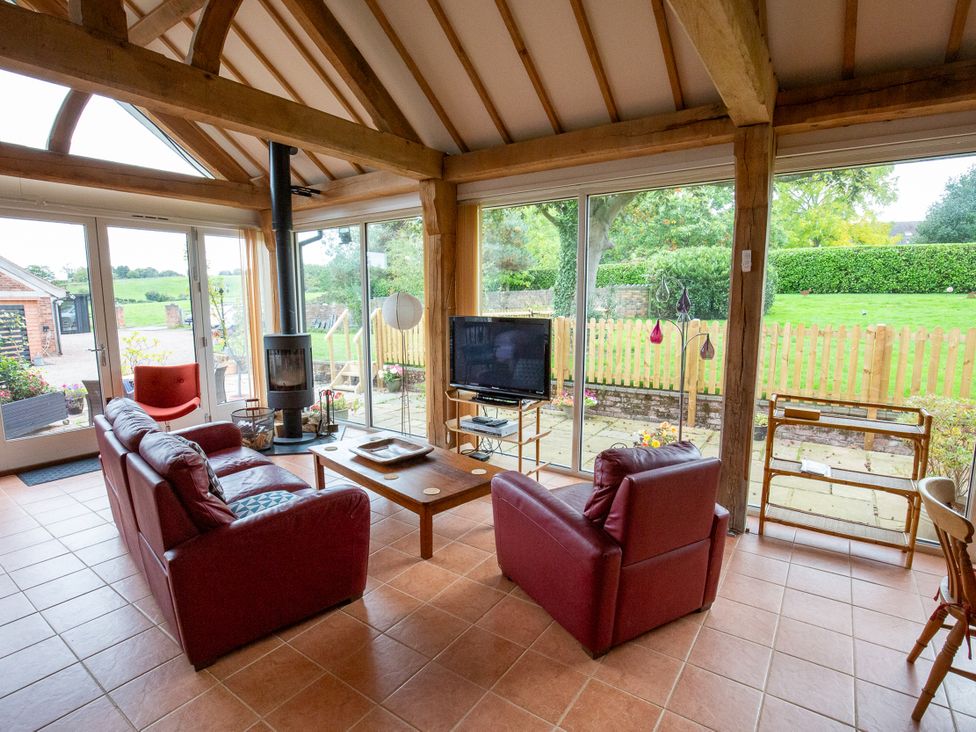 A living room with a television and sofa at Nature's Lodge in Cookley