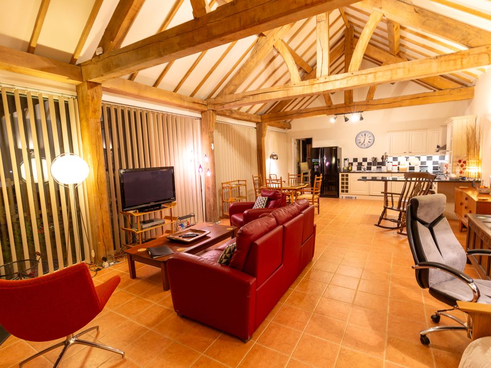 A living room with a sofa and television at Nature's Lodge in Cookley