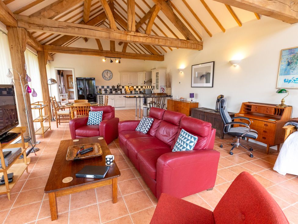 A living room with a sofa and dining area at Nature's Lodge in Cookley