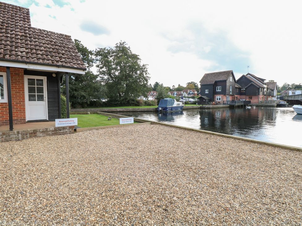 An outdoor area with a house and boats at Cotman Cottage in Hoveton & Wroxham