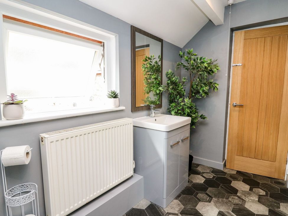 A bathroom with a sink and mirror at 6 Upperfield Street Dolgellau