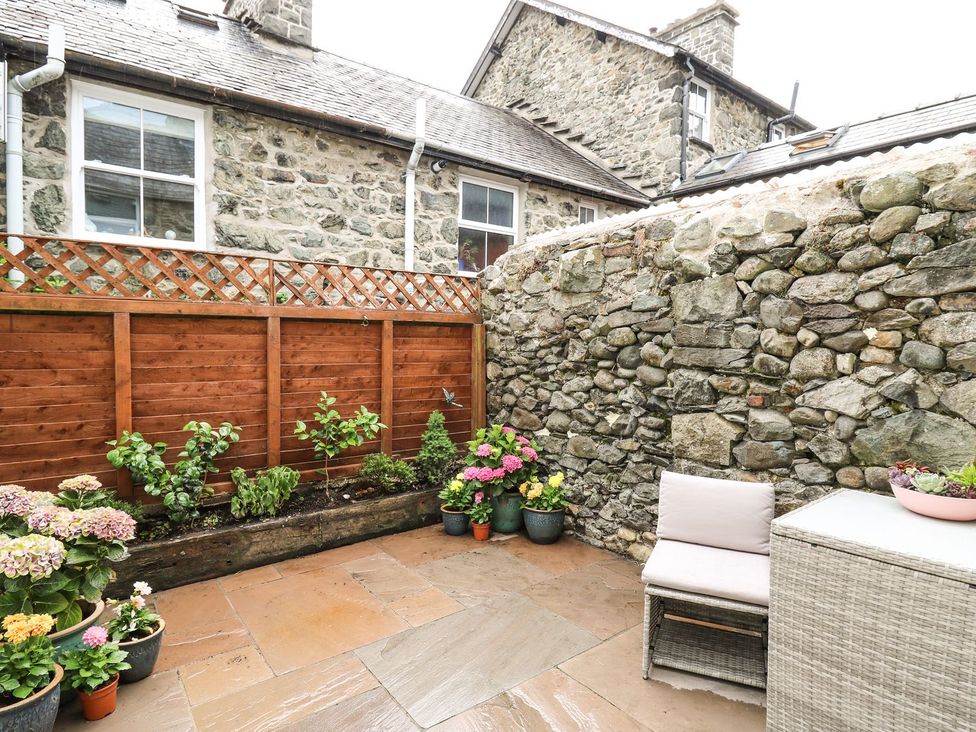 A garden with flowers and seating area at 6 Upperfield Street Dolgellau