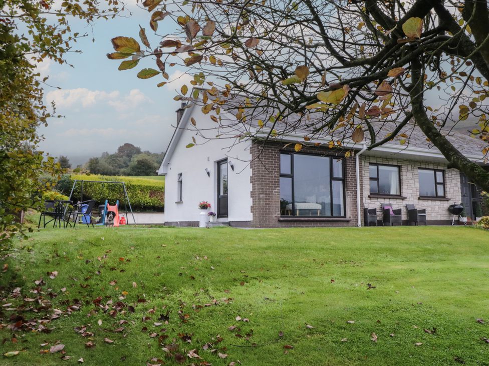 A house with a lawn and outdoor furniture at Lake view House Apartment