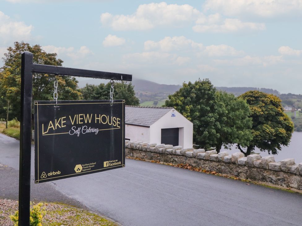 A sign for Lake View House Self Catering near a road by the lake