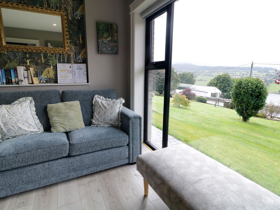 A living room with a sofa and a view outside at Lake view House Apartment