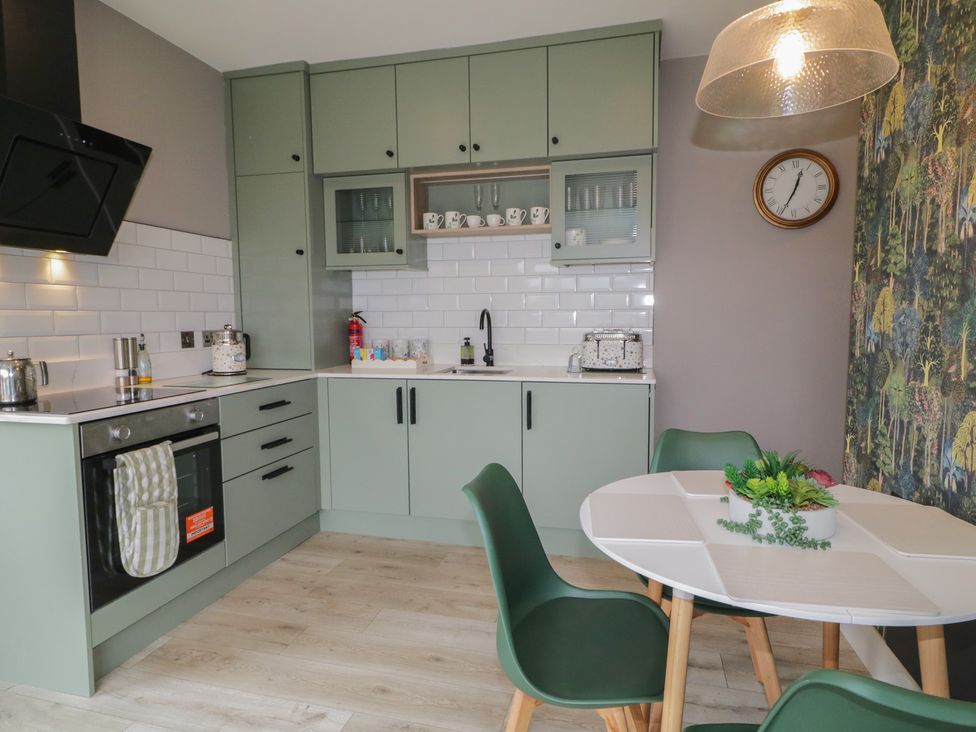 A kitchen with green cabinets and a dining table at Lake view House Apartment
