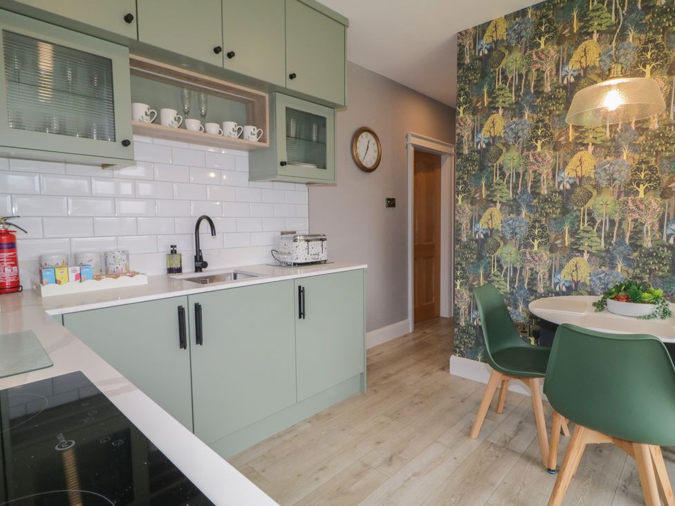 A kitchen with green cabinets and a dining table at Lake view House Apartment