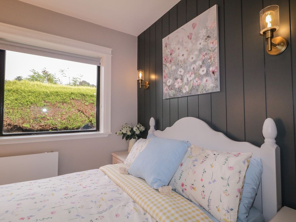 A bedroom with a bed, window, and wall art at Lake view House Apartment
