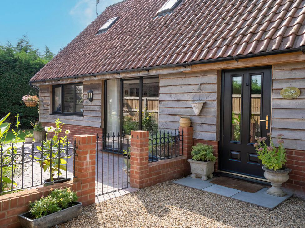 An outdoor area with a house and garden features at Foxley Lodge in Norwich