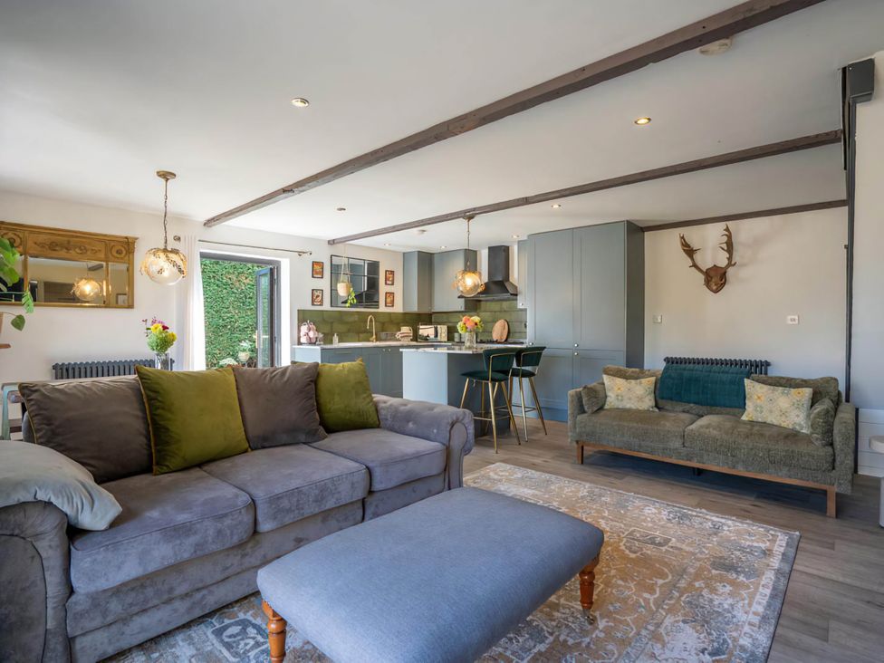 A living room with sofa and kitchen island at Foxley Lodge in Norwich