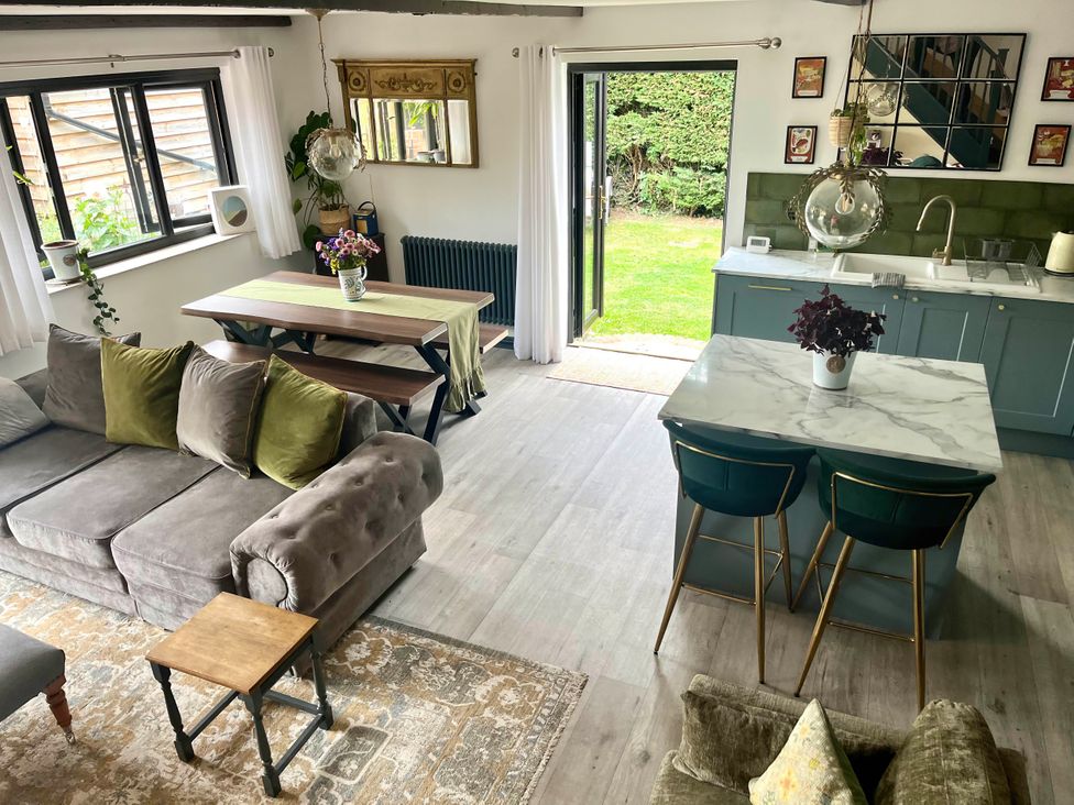 A living room with a sofa and dining area at Foxley Lodge in Norwich
